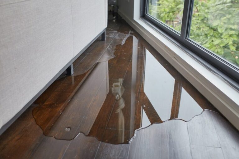 Water leaking and flooded on wood parquet floor. Room floor will damage after the water flooded.