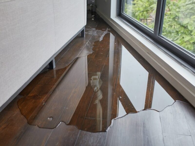 Water leaking and flooded on wood parquet floor. Room floor will damage after the water flooded.